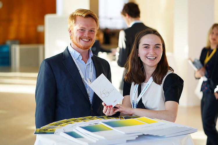 a man and a woman holding a flyer in their hand